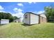Backyard showcasing multiple storage sheds, a lush lawn, and partial brick and vinyl siding at 1422 Duggins Dr, Burlington, NC 27217