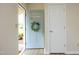 Light blue front door with address numbers and decorative wreath, opening to a clean, modern entryway at 1422 Duggins Dr, Burlington, NC 27217