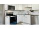 Close-up of modern kitchen showcasing white cabinets, stainless steel appliances, and a stylish backsplash at 1422 Duggins Dr, Burlington, NC 27217
