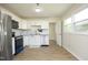 Modern kitchen featuring white cabinets, granite countertops, stainless steel appliances, and new laminate flooring at 1422 Duggins Dr, Burlington, NC 27217