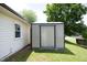 Home's vinyl storage shed with a corrugated metal roof, adjacent to the house and lawn at 1422 Duggins Dr, Burlington, NC 27217