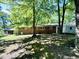 Backyard featuring a detached storage building, mature trees, and a brick home at 1713 S Garnett St, Henderson, NC 27536