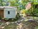 Backyard view of a home with lush landscaping and a storage building at 1713 S Garnett St, Henderson, NC 27536