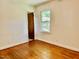 Bright bedroom featuring hardwood floors, neutral walls, and natural light from a window at 1713 S Garnett St, Henderson, NC 27536