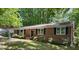 Traditional brick ranch home with a well manicured front yard and a black front door at 1713 S Garnett St, Henderson, NC 27536