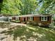 Traditional brick ranch home with a well manicured front yard and a black front door at 1713 S Garnett St, Henderson, NC 27536