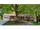 Charming brick home with an attached garage, a lush front yard, and mature trees at 1713 S Garnett St, Henderson, NC 27536