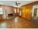 Cozy living room featuring wood paneling, brick fireplace and plank flooring at 1713 S Garnett St, Henderson, NC 27536