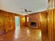 Cozy living room featuring wood paneling, brick fireplace and plank flooring at 1713 S Garnett St, Henderson, NC 27536