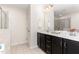 Bathroom with double sinks, dark wood cabinetry, and tiled floors at 172 Token House Rd, Durham, NC 27703