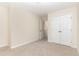 A bright bedroom with neutral carpet and walls, a ceiling light, and a double-door closet for storage at 172 Token House Rd, Durham, NC 27703