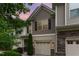 Charming townhouse features a tan exterior with brown accents, a one-car garage and manicured landscaping at 172 Token House Rd, Durham, NC 27703