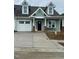 Inviting new construction showcasing green siding, one-car garage, and a concrete driveway at 1739 Old Fields Blvd, Haw River, NC 27258