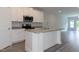 Modern kitchen featuring an island with granite countertops, stainless steel appliances, and a large window at 1739 Old Fields Blvd, Haw River, NC 27258