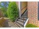 The side entrance of this townhome features well-maintained stairs and vibrant green bushes at 2201 Mountain Mist Ct # 202, Raleigh, NC 27603