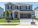 Charming two-story home with gray siding, black shutters, a red door and a two car garage at 2234 Cherry Creek Rd, Haw River, NC 27258