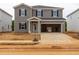 Two-story home featuring gray siding, black shutters, a front porch, and an attached two-car garage at 2234 Cherry Creek Rd, Haw River, NC 27258