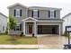 Charming two-story home featuring gray siding, black shutters, a red front door, and an attached two-car garage at 2234 Cherry Creek Rd, Haw River, NC 27258