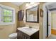 Cozy bathroom with dark wood vanity, medicine cabinet, and a window offering natural light at 2300 Cowden Ct, Raleigh, NC 27612