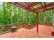 Inviting wooden deck featuring a pergola and scenic views of the lush surrounding trees at 2300 Cowden Ct, Raleigh, NC 27612