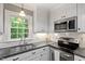 Well-lit kitchen featuring white cabinets, subway tile backsplash, and modern stainless steel appliances at 2300 Cowden Ct, Raleigh, NC 27612