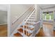 Elegant stairway with wood steps, white railings, and natural light streaming in at 2300 Cowden Ct, Raleigh, NC 27612