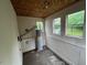 Utility room with hot water heater and two bright windows overlooking the backyard at 246 Keene St, Henderson, NC 27536