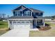 Charming two-story home boasts a striking blue exterior, complemented by a stone-accented garage and well-manicured landscaping at 301 New Twin Br Ct, Smithfield, NC 27577