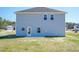 Rear exterior of a two-story home with blue siding, gray shingles, and a small patio at 301 New Twin Br Ct, Smithfield, NC 27577