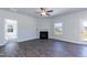 Open-concept living room with a fireplace, ceiling fan, and door that leads to the backyard at 301 New Twin Br Ct, Smithfield, NC 27577