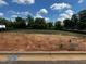 Vacant lot with graded dirt and grass with new home construction in the background at 301 New Twin Br Ct, Smithfield, NC 27577