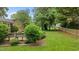 This is a lush backyard with a brick patio and wooden bench next to a charming fence at 307 Pine Tree Rd, Oxford, NC 27565