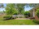 Secluded backyard showcasing a unique built-in bench, surrounded by mature trees and lush greenery at 307 Pine Tree Rd, Oxford, NC 27565