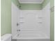 Bathtub and shower combination featuring a shower head, shelves, and white tile at 307 Pine Tree Rd, Oxford, NC 27565