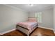 A cozy bedroom features hardwood floors, neutral walls, and a comfortable bed at 307 Pine Tree Rd, Oxford, NC 27565