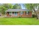 Charming brick home featuring a well-manicured front yard, bright blue front door, and classic shutters at 307 Pine Tree Rd, Oxford, NC 27565