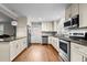 Well-lit kitchen with stainless steel appliances, granite countertops, white cabinets, and hardwood flooring at 307 Pine Tree Rd, Oxford, NC 27565