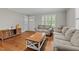 Inviting living room featuring hardwood floors, two sofas, two windows with shutters, and natural light at 307 Pine Tree Rd, Oxford, NC 27565