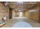 Spacious unfinished basement with exposed ceiling and brick and wood paneled walls at 3216 Green Valley Dr, Sanford, NC 27330