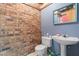 Basement half bathroom featuring brick wall accent and pedestal sink at 3216 Green Valley Dr, Sanford, NC 27330