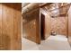 Hallway with brick and wood paneled walls connecting basement rooms at 3216 Green Valley Dr, Sanford, NC 27330