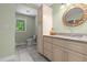 A bathroom features tiled flooring, vanity storage, a window view, and a light-green painted wall at 3216 Green Valley Dr, Sanford, NC 27330
