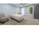 A light blue bedroom with carpet features a window and a chair with white curtains at 3216 Green Valley Dr, Sanford, NC 27330