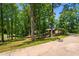 Single-story home nestled among mature trees, features a long driveway and lush landscaping at 3216 Green Valley Dr, Sanford, NC 27330