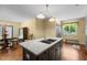An open kitchen features a kitchen island with a stone countertop and a stainless steel sink and faucet at 3216 Green Valley Dr, Sanford, NC 27330