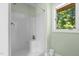 The all white shower is next to a window and has green painted walls, and a white trash can at 3216 Green Valley Dr, Sanford, NC 27330