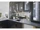 Modern wet bar with sleek black cabinetry, a sink, and a mirrored backsplash at 3407 Churchill Rd, Raleigh, NC 27607
