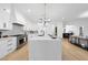 Bright kitchen with a large island featuring stone countertop, white cabinets, and stainless steel appliances at 3407 Churchill Rd, Raleigh, NC 27607