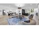 Open-concept living room with modern chandelier, hardwood floors, and seamless flow to kitchen at 3407 Churchill Rd, Raleigh, NC 27607