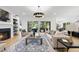 Bright living room featuring hardwood floors, a fireplace, modern lighting, and large sliding glass doors at 3407 Churchill Rd, Raleigh, NC 27607